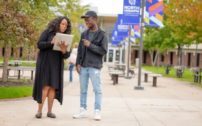 two students standing outside talking