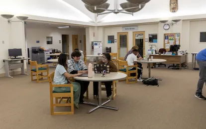 students working at a table with a tutor