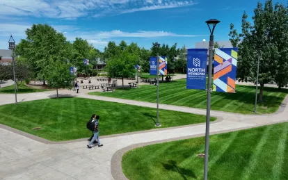 drone shot of campus in the summer with students walking 
