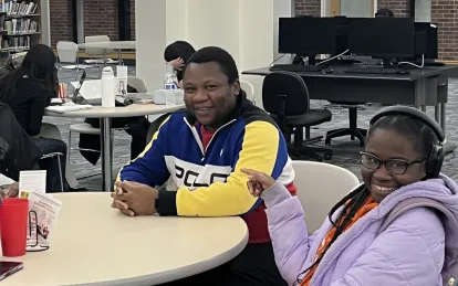 three people sitting at a table smiling 