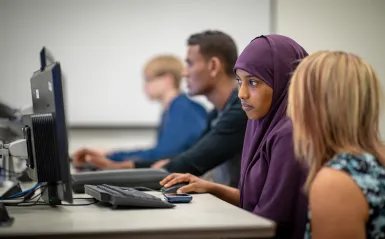 Female student at a computer with instructor