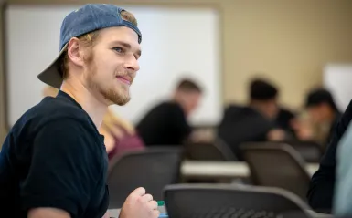 Male student smiling in a classroom 