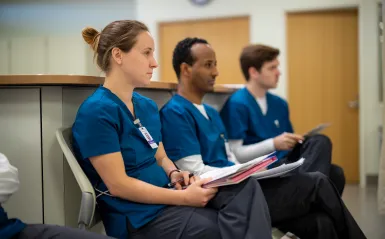 three nursing students sitting taking notes