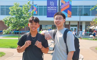 two students outside smiling on a nice day