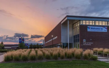 Large business and technology building in the evening with the sun setting in the background. 