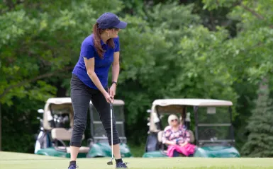 woman about to hit a golf ball