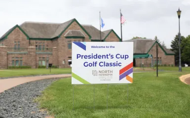 picture f a sign saying 'president's cup golf classic' outside a building