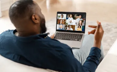 man on a laptop speaking to people on laptop 
