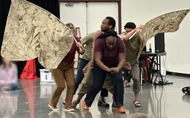 An image of actors on stage performing as an elephant