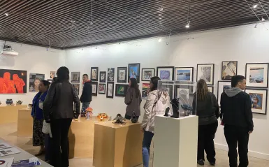 people in the gallery gather to view the art