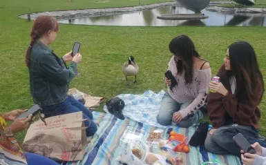group of people sitting eating food looking at a bird