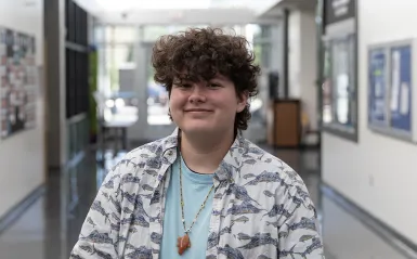person smiling in hallway wearing a colorful shirt 