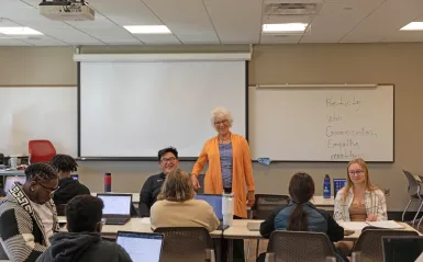students in a classroom talking with an instructor