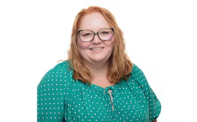 woman smiling and wearing glasses with a white background