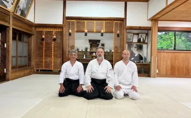 this is a photo of NHCC faculty Mark Larson and NHCC alumni Kyle Knutson sitting on the floor at the Iwama Dojo, Birthplace of Aikido in Japan. 