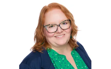 woman smiling and wearing glasses with a white background