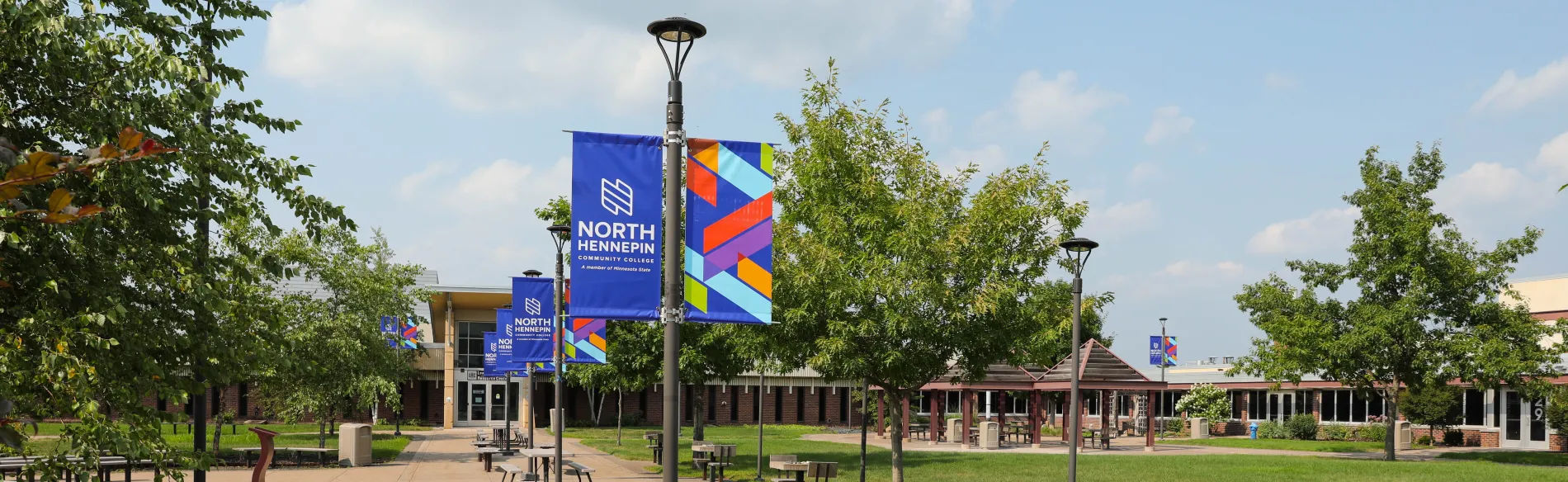 Campus courtyard with picnic tables and branded banners