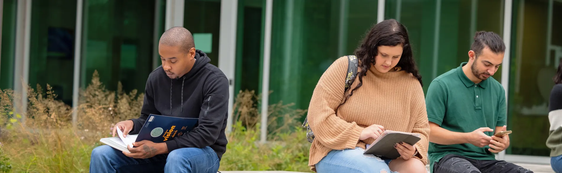 Three students sitting outside 