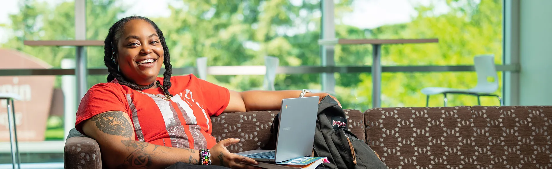 woman sitting on a couch with laptop smiling 