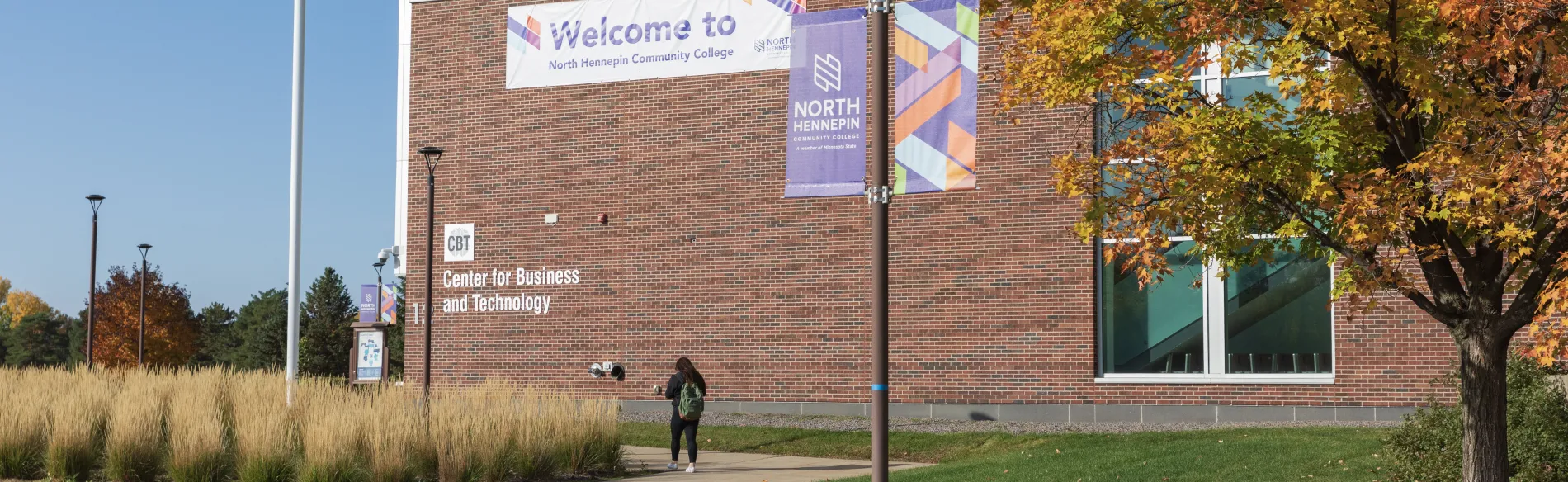 student walking into campus building in the fall 