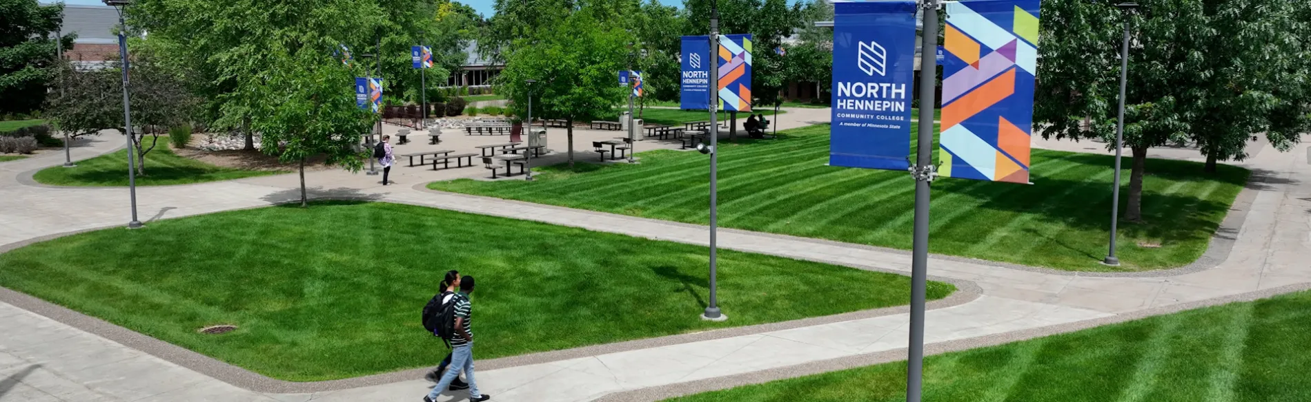 drone shot of campus in the summer with students walking 