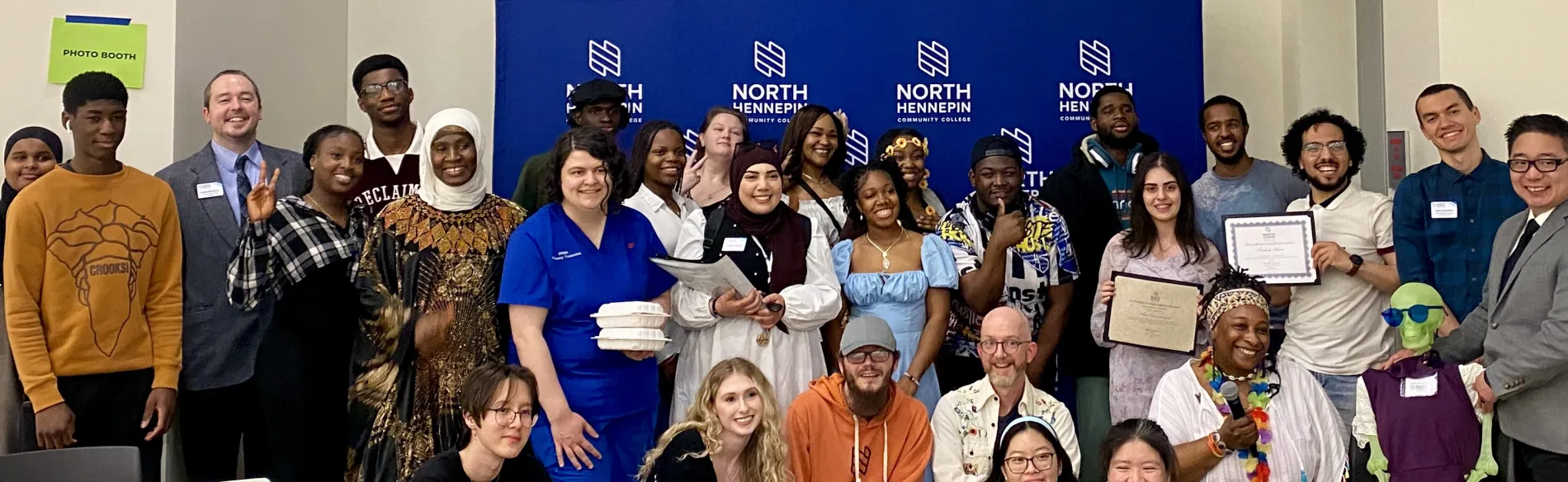 This is a group photo of various students and staff who attended the Student Life Awards Banquet. The group piled together for a photo in front of the NHCC logo backdrop. 