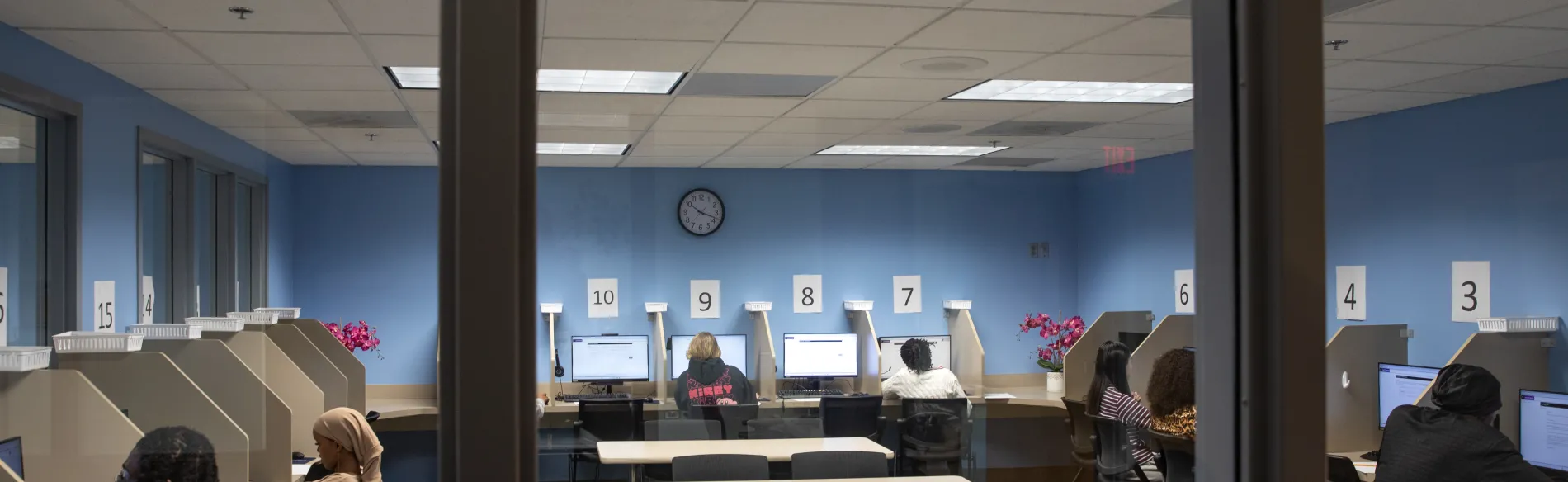 students sitting at small tables with computers