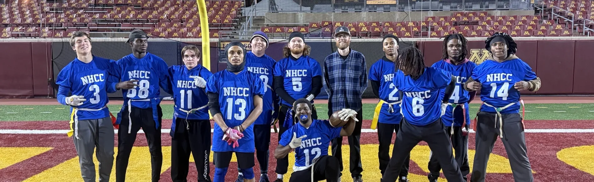 group of students in football uniforms standing outside on a field with the goal post
