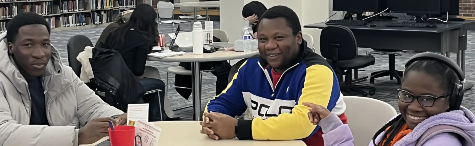 three people sitting at a table smiling 