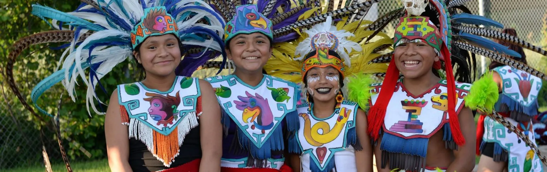 four smiling young kids dressed in colorful attire