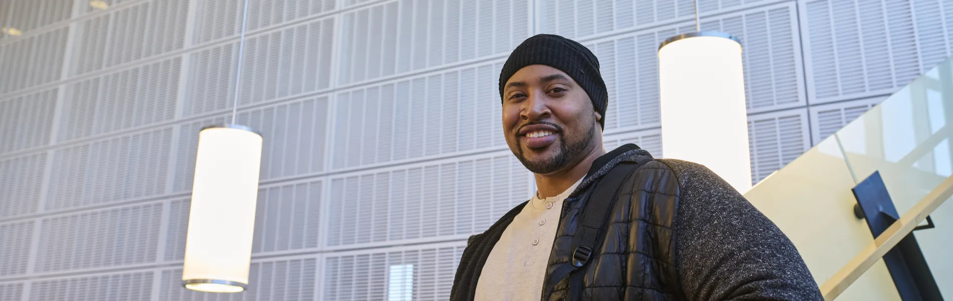 student standing on stairs smiling 