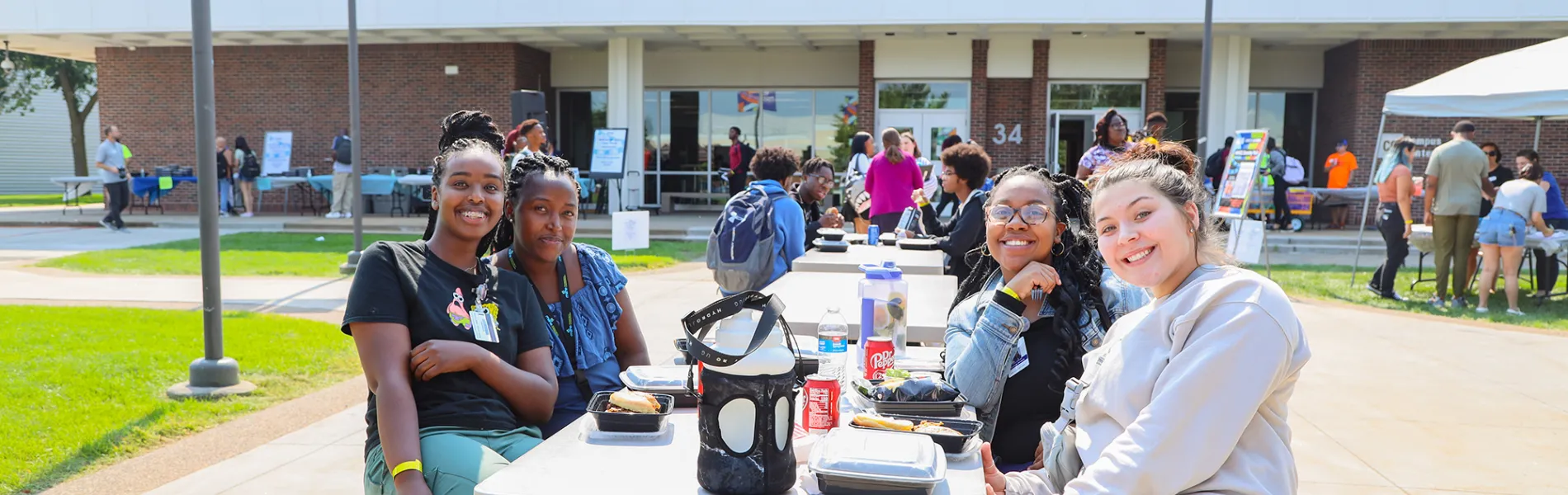 students sitting at a table outside smiling