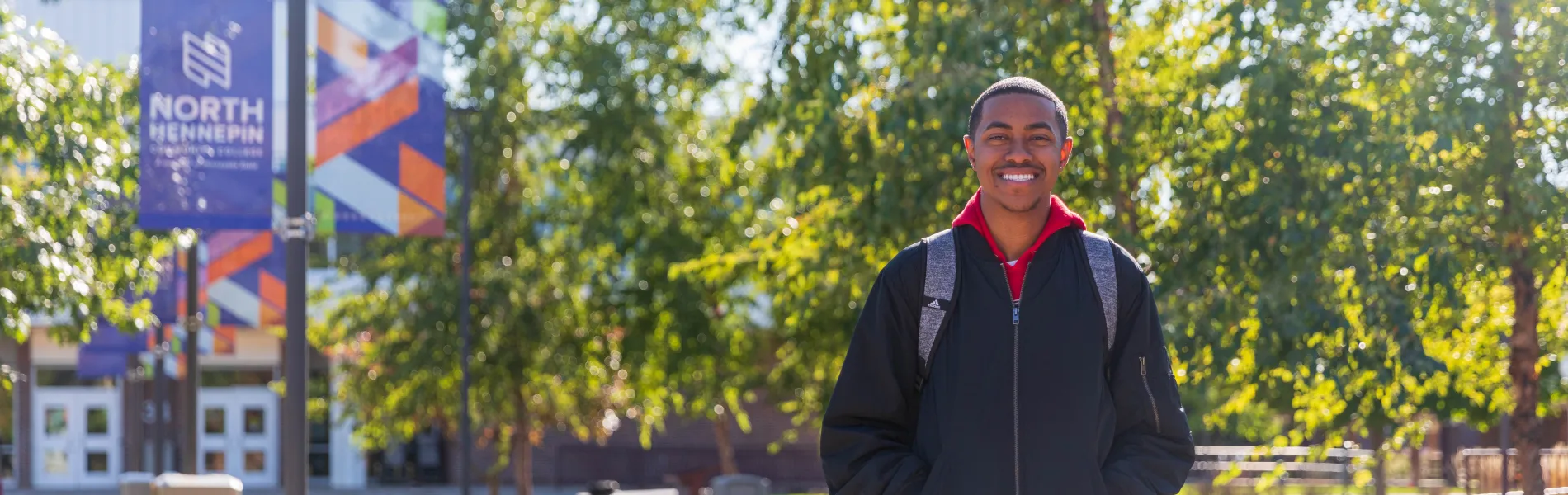 student standing outside smiling on a sunny day