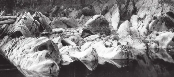 black and white photo of rocks near still water 