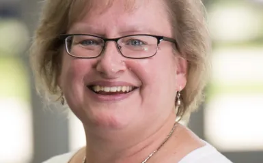 Paralegal Program Director & Instructor, Mary Fenske standing outside smiling at the camera