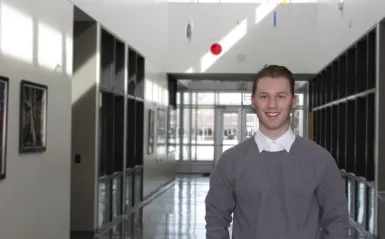 student Nathan standing in a hallway