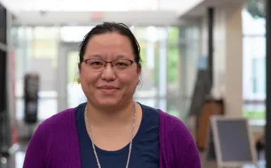 computer science student Lillian Ahles inside smiling and facing camera 