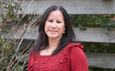 faculty member and veteran Janet Lorenzo standing outside smiling at the camera