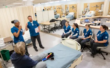 students in a nursing lab in a group talking