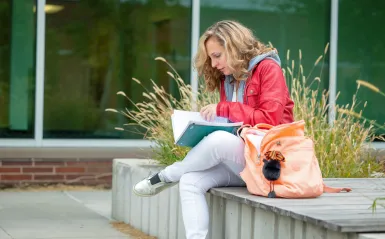 female, adult student studying outside
