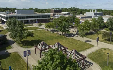 arial view of campus courtyard with trees buildings and a few students 
