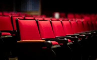 a row of red seats in a theater 