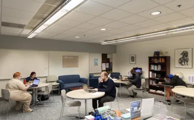 students on laptops in the writing center