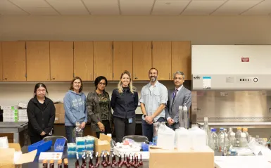 a group standing by lab equipment 