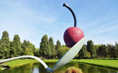 sculpture of cherry on a spoon over water
