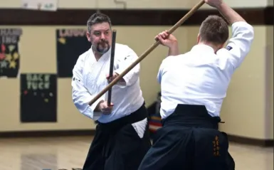 two men using wooden swords 