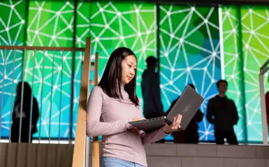 a photo of a female student with a laptop on-campus 