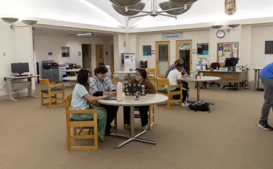students working at a table with a tutor