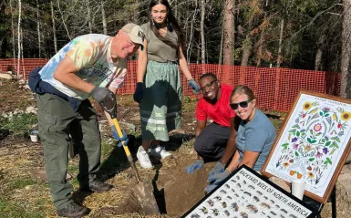 students digging in dirt outside with an instructor 