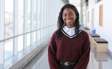 this is a photo of NHCC biology student, Danista Kannah, smiling in the hallway of the BHCC building on the 2nd floor. 